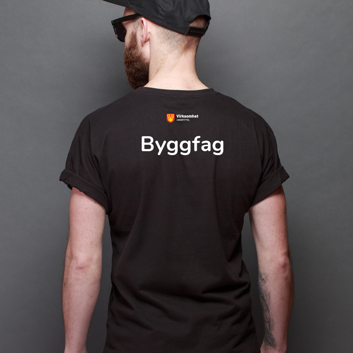Svart t-skjorte med virksomhetslogo og teksten Byggfag på ryggen