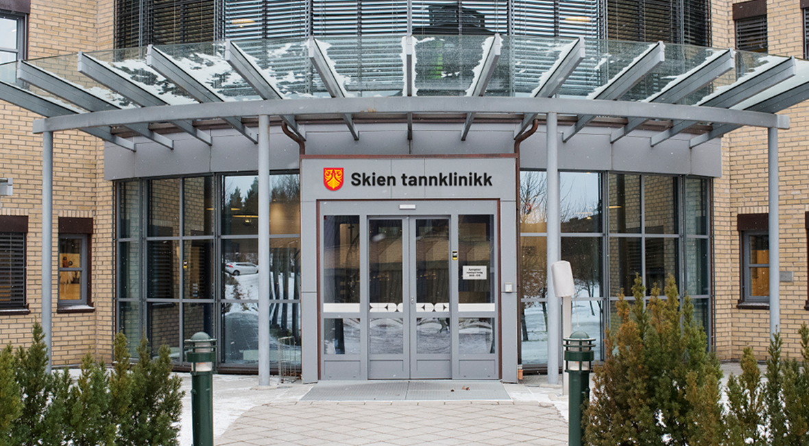 Inngangspartiet til Skien tannklinikk med logo som navnelinje over dørene
