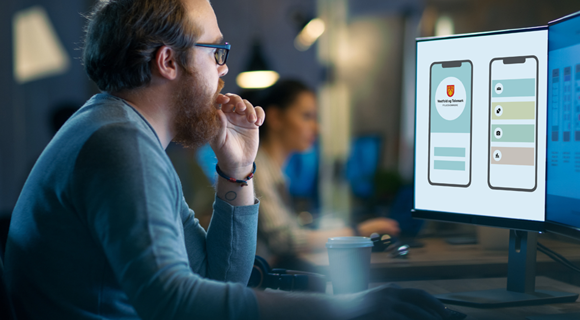 En mann jobber og ser på en PC-skjerm. På skjermen vises mockups av mobilflater med oppsett av logo og former i støttefarger.